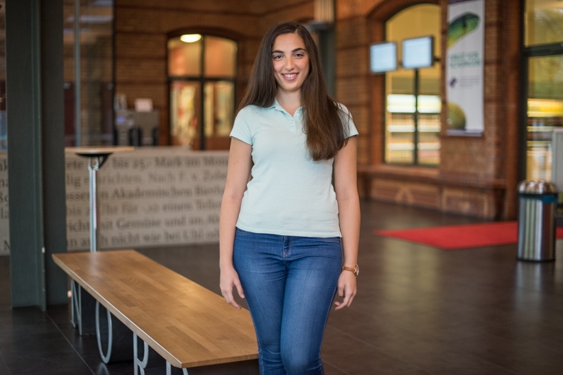 Praktikantin steht im Foyer eines Studentenwerks