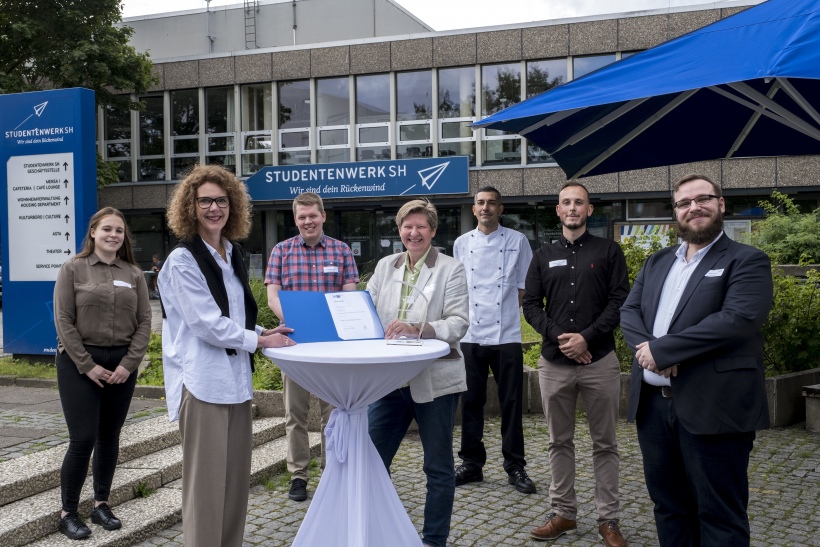 Feierliche Übergabe der Auszeichnung: Auszubildende Natascha Bauer, IHK-Vizepräsidentin Ulrike Jacobi, Auszubildender Finn Wehrmacher, Studentenwerks-Geschäftsführerin Susann Schrader, Auszubildender Fatih Yazkan, Auszubildender Kevin Schreckenberg und Au